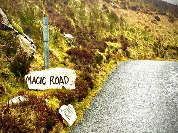 This is a photo of the Mamore Gap in Donegal, Ireland with a sign saying Magic Road.